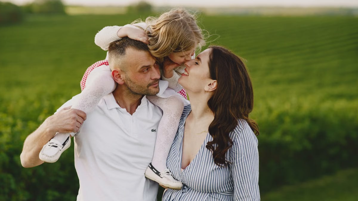 A delightful family moment captured in a lush scenic field, portraying love and happiness.